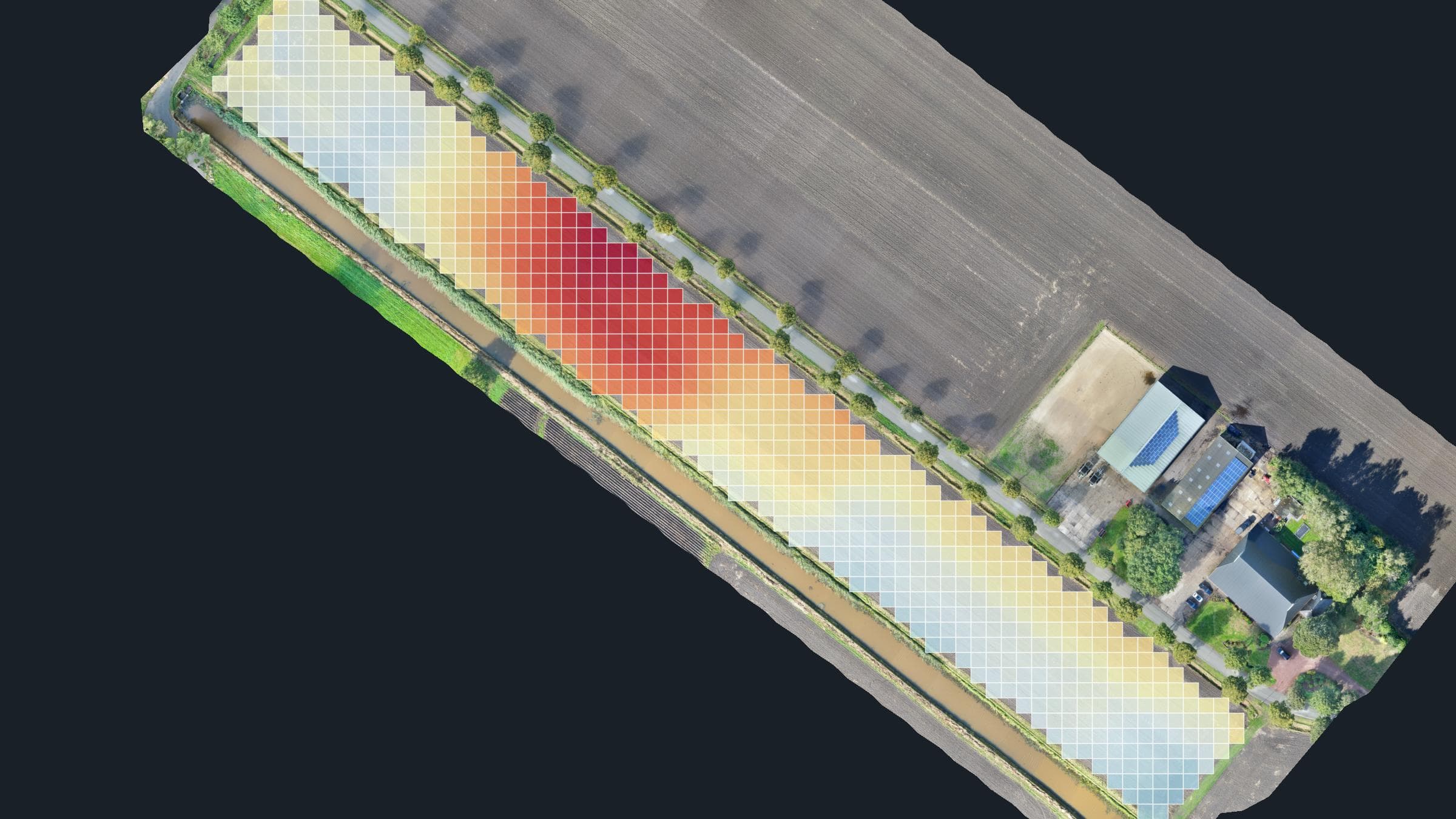 Kilverkaart over de luchtfoto van een langgerekt perceel: een raster van vakken, gekleurd van lichtblauw voor de lage delen tot dieprood voor de hoogste zone